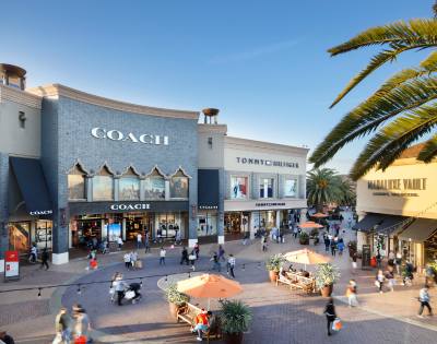 Another exterior view of Citadel Outlets showing stores and people shopping.