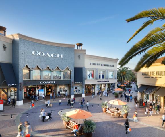 Another exterior view of Citadel Outlets showing stores and people shopping.