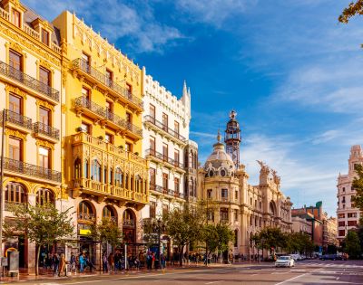 A bright cityscape of Valencia, Spain showcases colorful buildings under a clear blue sky.