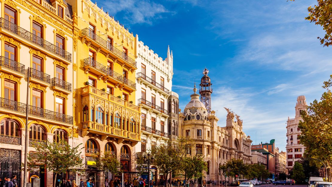 A bright cityscape of Valencia, Spain showcases colorful buildings under a clear blue sky.
