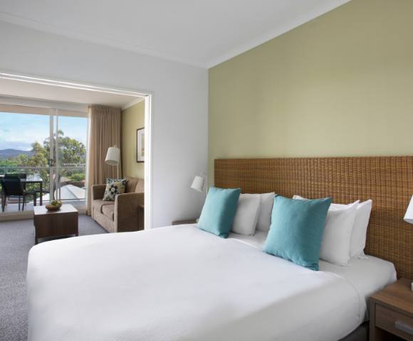 Comfortable bedroom in a 1-bedroom spa suite at Mantra Ettalong Beach with stylish decor