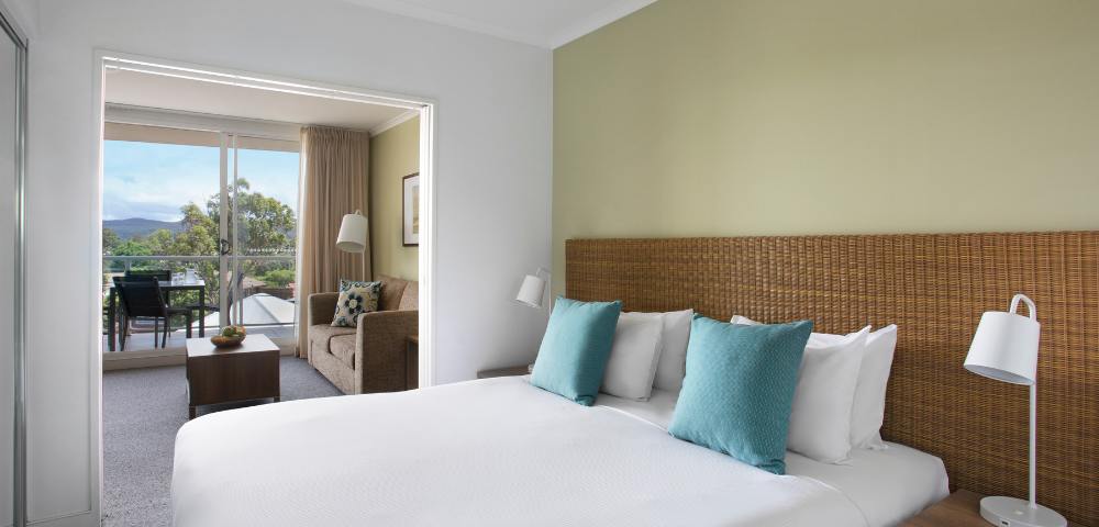 Comfortable bedroom in a 1-bedroom spa suite at Mantra Ettalong Beach with stylish decor