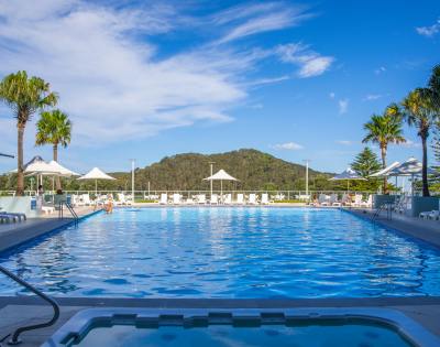 Aerial view of Mantra Ettalong Beach resort featuring a large swimming pool and surrounding buildings