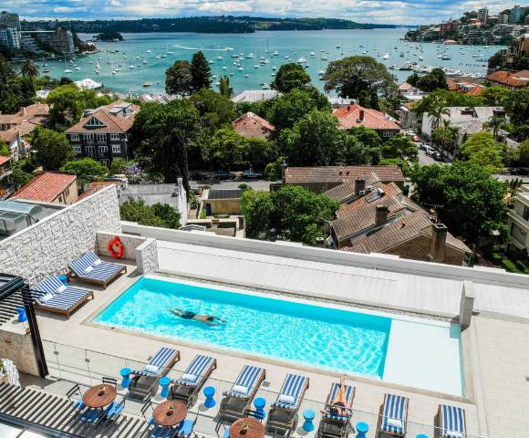 Aerial view of an outdoor pool surrounded by lounge chairs and greenery