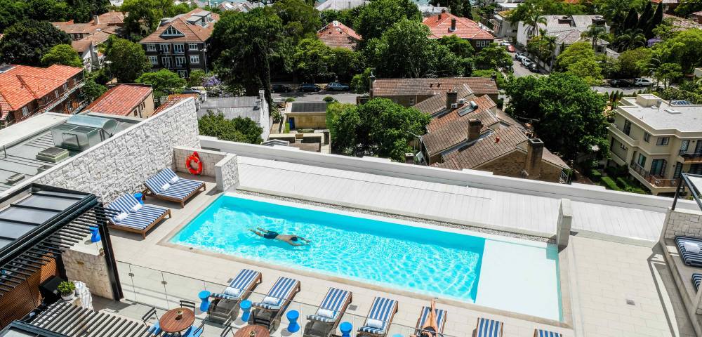 Aerial view of an outdoor pool surrounded by lounge chairs and greenery