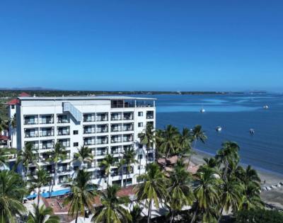 Another elevated view of the same building, emphasizing its greenery and coastal location.