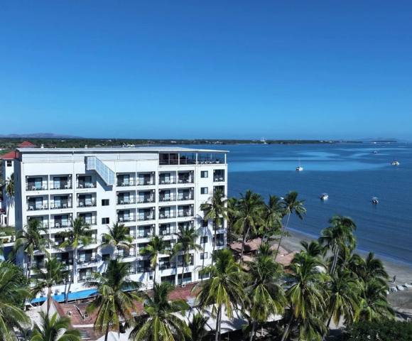 Another elevated view of the same building, emphasizing its greenery and coastal location.