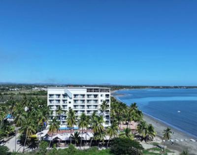 Alternate angle of a coastal building, showing nearby structures and the surrounding water.