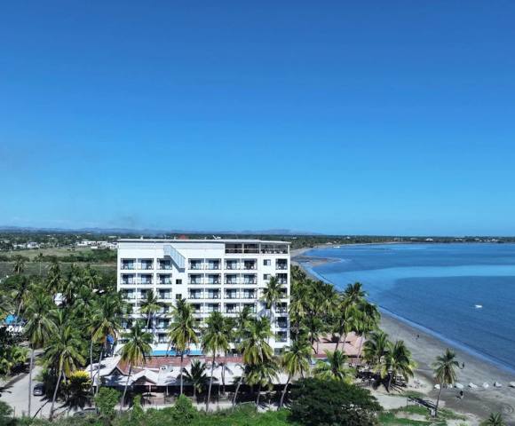 Alternate angle of a coastal building, showing nearby structures and the surrounding water.