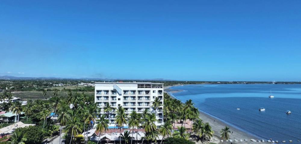 Alternate angle of a coastal building, showing nearby structures and the surrounding water.