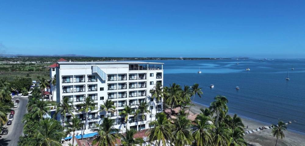 Another elevated view of the same building, emphasizing its greenery and coastal location.