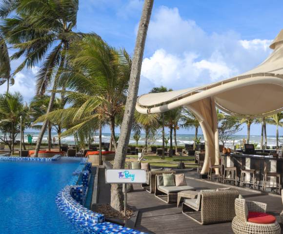 Outdoor pool area surrounded by palm trees and lounge chairs, designed for relaxation and leisure