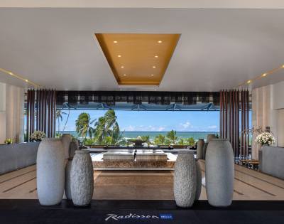 Hotel lobby during daylight hours, featuring sophisticated decor and an open layout with views to the outside.