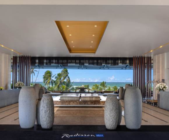 Hotel lobby during daylight hours, featuring sophisticated decor and an open layout with views to the outside.