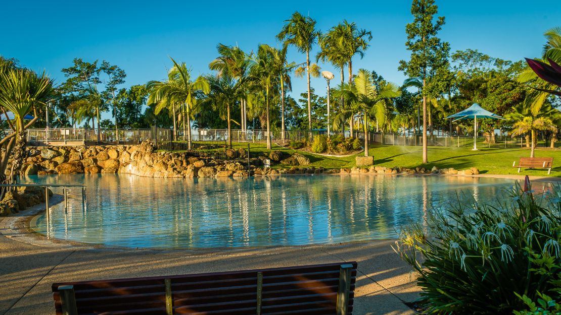 Serene water body surrounded by palm trees.