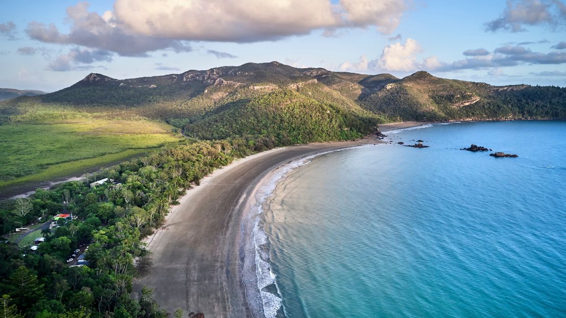 Beautiful beach with clear blue water and lush greenery.