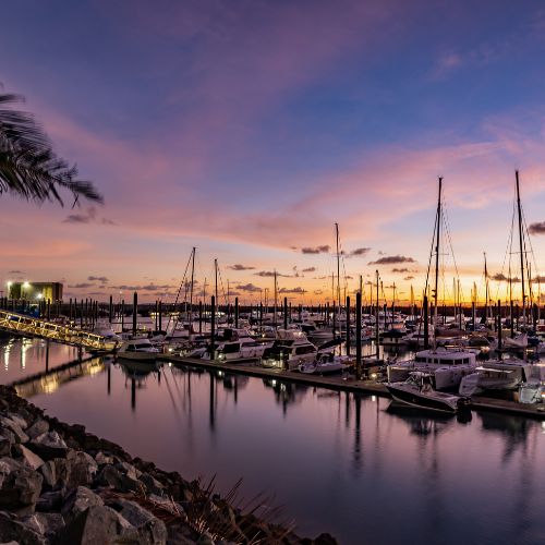Marina with boats docked at sunset.