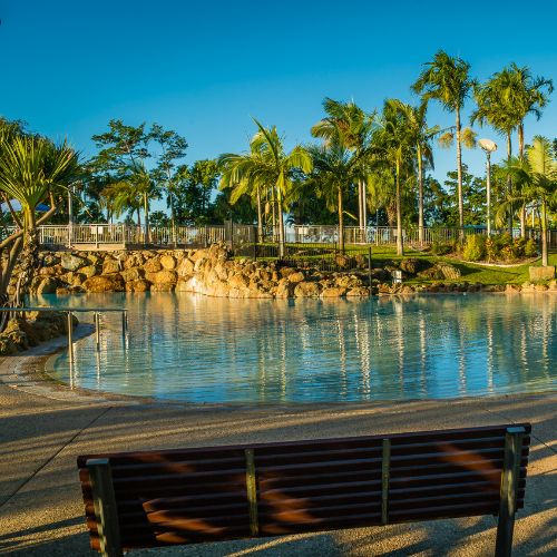 Serene water body surrounded by palm trees.