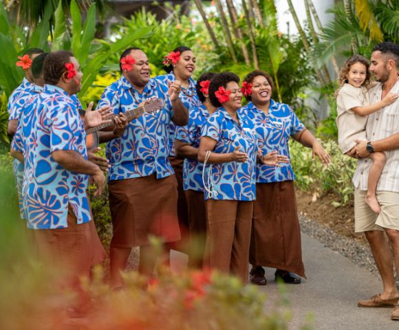 Resort staff in colorful uniforms posing together.
