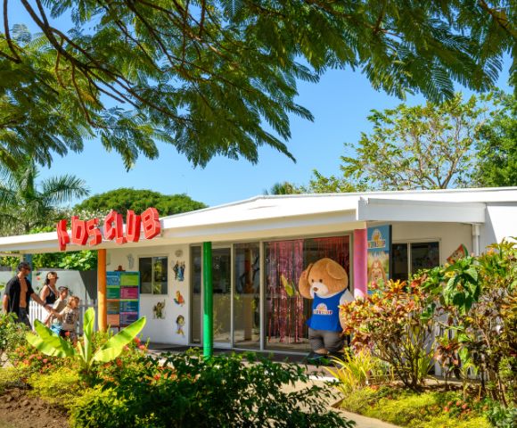 Exterior view of a kids’ club building surrounded by greenery.