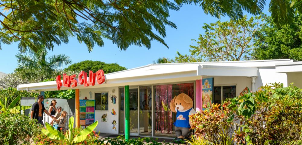 Exterior view of a kids’ club building surrounded by greenery.