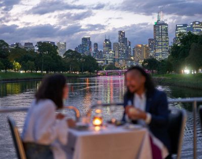 Romantic dinner setting on a river cruise with sunset view over Melbourne.