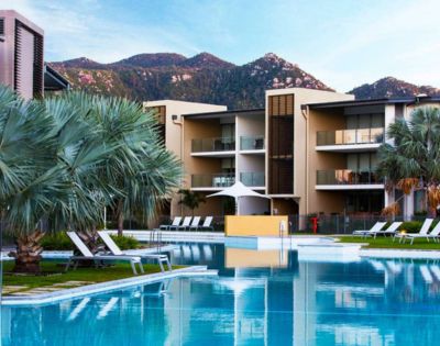 3. Bright, minimalist bathroom with a large mirror reflecting a modern sink, chrome faucet, and white towels. The atmosphere is clean and serene.