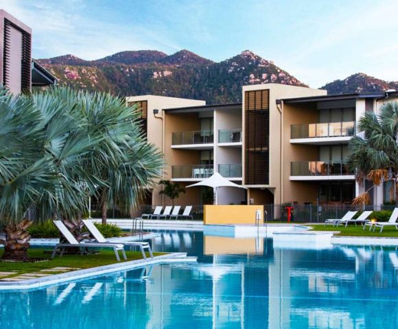 3. Bright, minimalist bathroom with a large mirror reflecting a modern sink, chrome faucet, and white towels. The atmosphere is clean and serene.