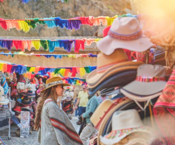 A vibrant market stall displaying colorful textiles and handmade crafts. Bright fabrics and intricate patterns create a lively cultural atmosphere.