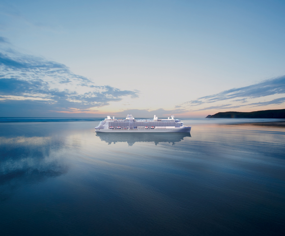 A large cruise ship sails on calm waters at sunset, reflecting a tranquil sky with soft pink and blue hues. The scene conveys peace and grandeur.