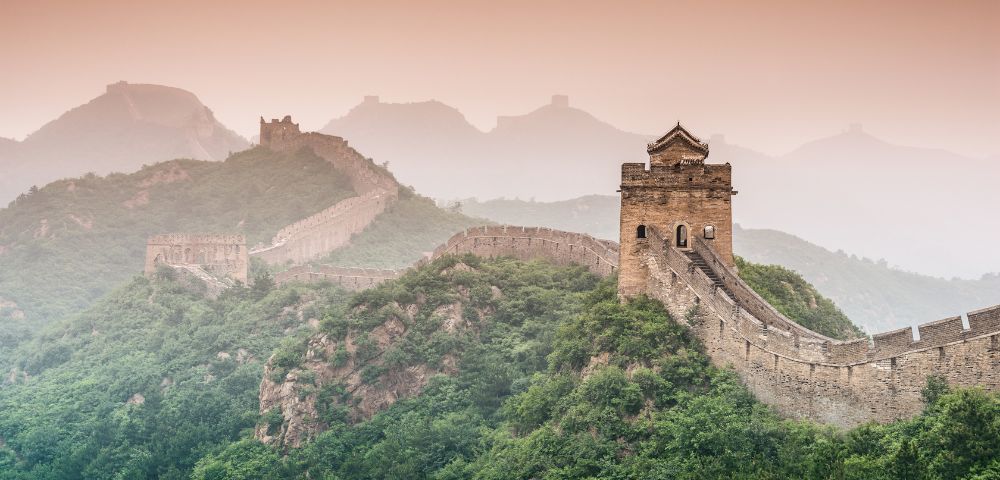 The Great Wall of China stretches across mountains, a stunning and iconic tourist attraction.