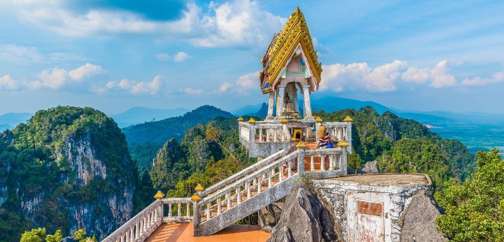 The summit of a mountain in Thailand, showcasing lush greenery and a clear blue sky.