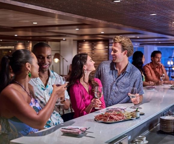 A group of friends enjoying drinks and conversation at a stylish bar, surrounded by an elegant ambiance and delicious appetizers.