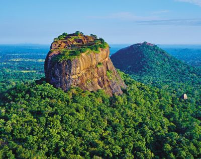 Aerial view of a coastal town with a lighthouse and historic fort walls surrounded by the sea.