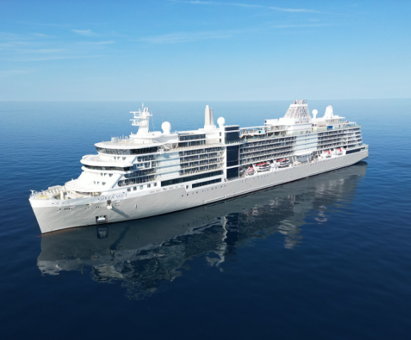 A large white cruise ship sails smoothly on a calm, deep blue ocean under a clear sky, reflecting peacefulness and luxury travel.
