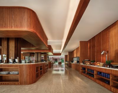 Alt text: Modern kitchen with wooden cabinetry and countertops, featuring sleek recessed lighting. The space is neat, warm, and inviting, with an organized setup.