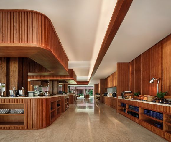 Alt text: Modern kitchen with wooden cabinetry and countertops, featuring sleek recessed lighting. The space is neat, warm, and inviting, with an organized setup.