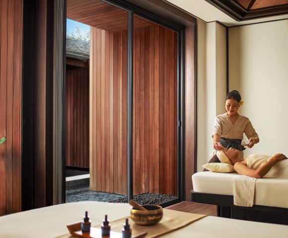 A person receiving a massage in a serene spa setting, with wooden walls and soft lighting. Relaxation and tranquility are emphasized.
