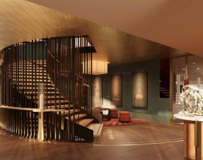 Luxurious hotel lobby with a spiral staircase, warm lighting, modern art on walls, and plush seating. The ambiance is elegant and inviting.