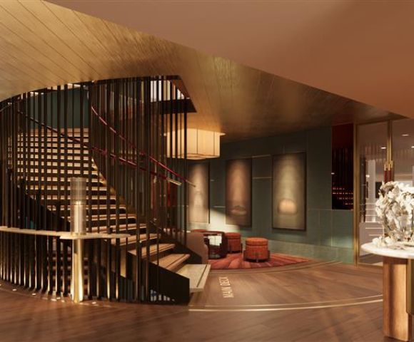 Luxurious hotel lobby with a spiral staircase, warm lighting, modern art on walls, and plush seating. The ambiance is elegant and inviting.