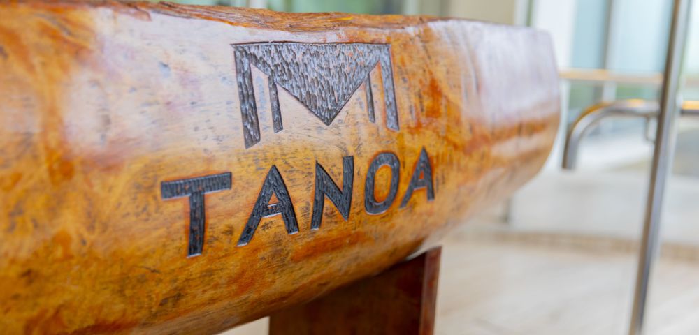 Close-up of a carved wooden bowl with the word 