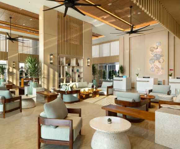 Modern hotel lobby with light wood accents, elegant seating, and soft lighting. The setting conveys a welcoming and serene atmosphere.