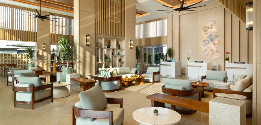 Modern hotel lobby with light wood accents, elegant seating, and soft lighting. The setting conveys a welcoming and serene atmosphere.