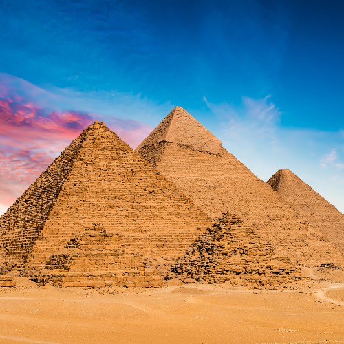 Ancient pyramids under a vibrant sky blend with the desert landscape, conveying a sense of timeless grandeur and mystery.