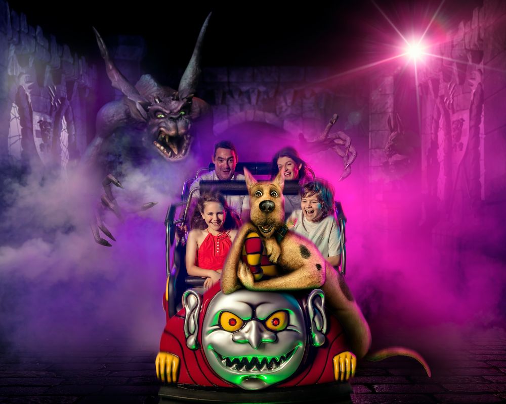 A thrilled family and Scooby-Doo ride a spooky roller coaster, surrounded by purple fog and a menacing monster, creating a fun and eerie atmosphere.