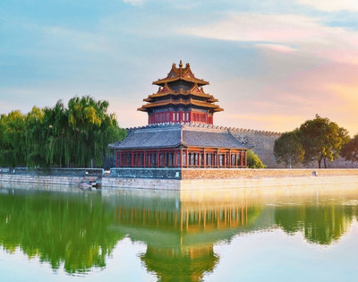 Ancient Chinese pavilion by a calm river, surrounded by lush greenery under a vibrant sunset sky, reflecting tranquility and beauty.