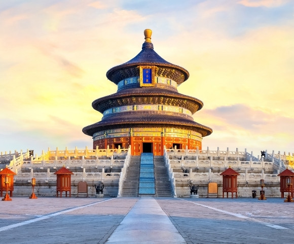 The Temple of Heaven in Beijing, China during sunset with a colorful sky and empty courtyard.