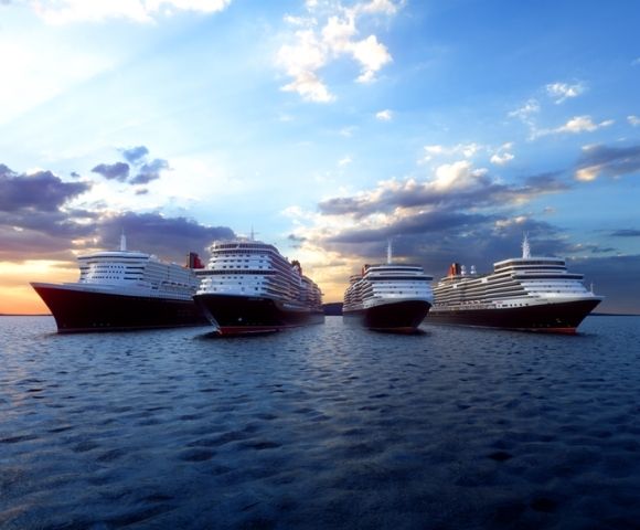 Large cruise ships aligned on calm ocean water during sunset, with golden sunlight on the left and a blue sky with scattered clouds above