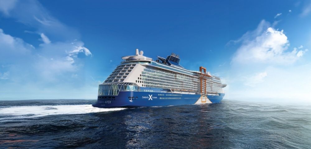 A large blue and white cruise ship, the Celebrity Apex, sails through dark blue ocean waters under a bright blue sky with scattered white clouds.