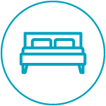 Icon of a double bed with a headboard inside a circular border, representing accommodations or a bedroom.